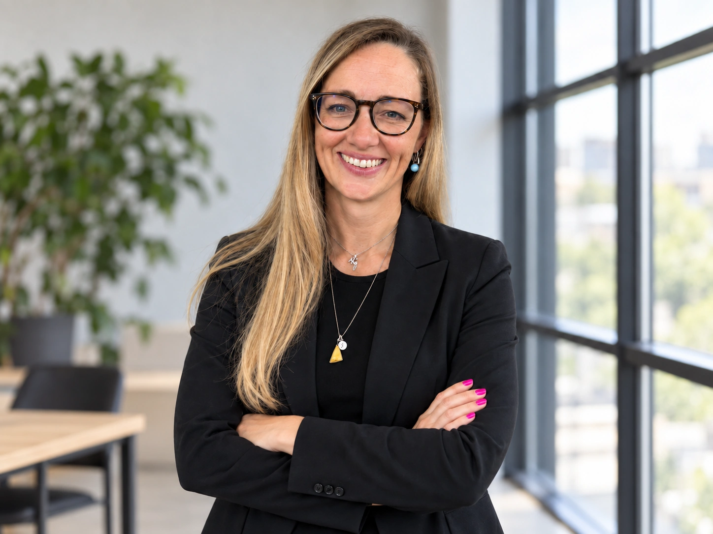 Jenny Beutnagel in a black blazer, with her arms loosely folded and a friendly expression.