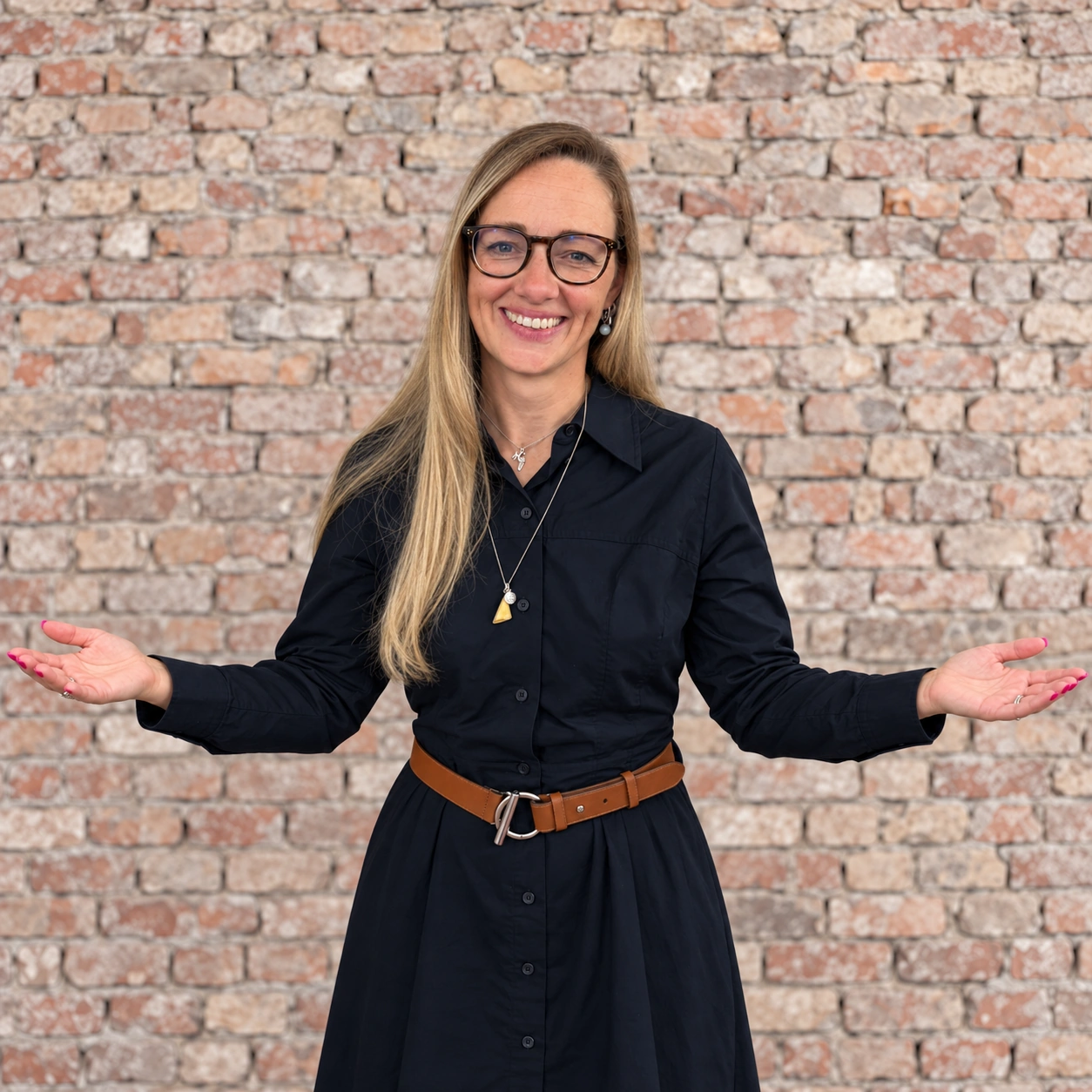 Jenny Beutnagel smiling with a relaxed expression and her arms open, palms facing up.